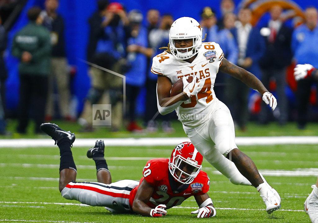 Butch Dill Texas wide receiver Lil'Jordan Humphrey (84) carries past Georgia defensive back J.R. Reed (20) on a pass reception in the first half of the Sugar Bowl NCAA college football game in New Orleans, Tuesday, Jan. 1, 2019. (AP Photo/Butch Dill)