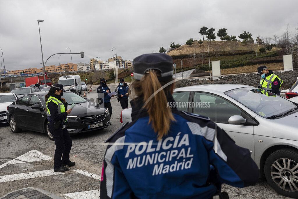 Bernat Armangue A police officer checks a driver's documents at a checkpoint on the outskirts of Madrid, Spain, Monday, Jan. 25, 2021. With several regions reporting Friday new daily records of infections, some regional governments are toughening their response. The central Madrid region, home to 6.6 million, brought its curfew from midnight to 10 p.m. starting on Monday, and ordered shop, bar and restaurant closures at 9 p.m. the latest. (AP Photo/Bernat Armangue)