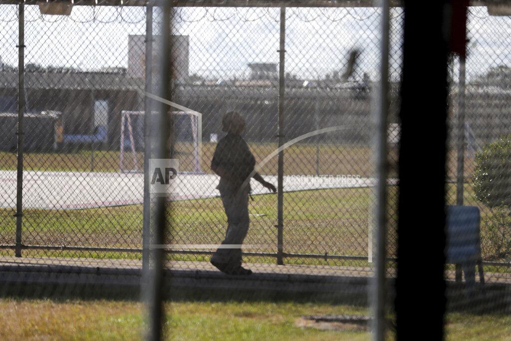 Gerald Herbert FILE — In this Sept. 26, 2019 file photo, a guard walks on a path between yards during a media tour inside the Winn Correctional Center, in Winnfield, La. The number of detainees nationwide has more than doubled since the end of February 2021, to nearly 27,000, according to recent data from U.S. Immigration and Customs Enforcement. (AP Photo/Gerald Herbert, File)