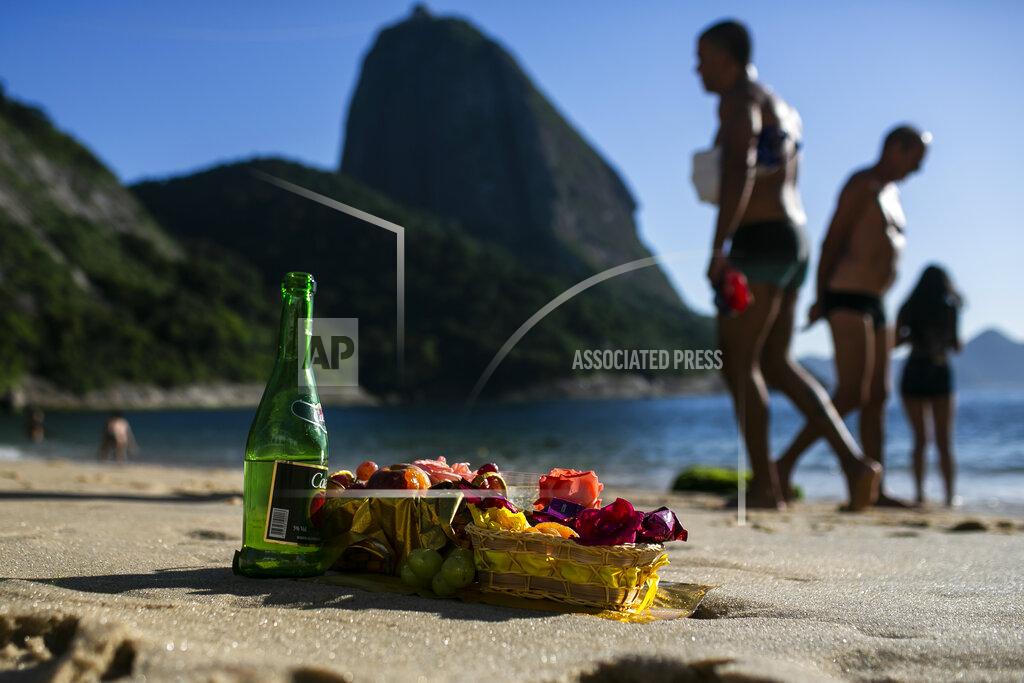 Bruna Prado Offerings in honor of the Goddess of the Sea Yemanja sit on Praia Vermelha beach to mark the end of the year in Rio de Janeiro, Brazil, on New Year's Eve, Thursday, Dec. 31, 2020. Beaches will be closed on the night of new years, to help curb the spread of COVID-19. (AP Photo/Bruna Prado)