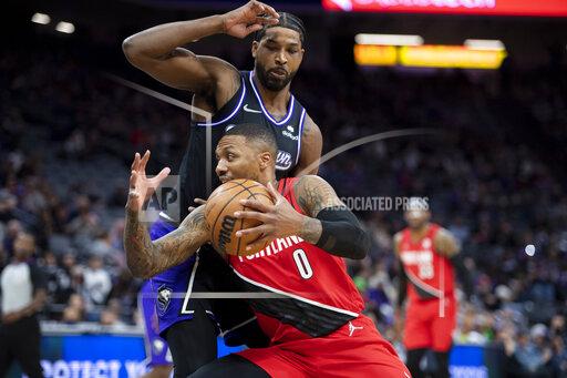 Portland Trail Blazers guard Damian Lillard (0) drives past Sacramento Kings center Tristan Thompson (13) during the first quarter of an NBA basketball game in Sacramento, Calif., Wednesday, Nov. 24, 2021. (AP Photo/José Luis Villegas)
