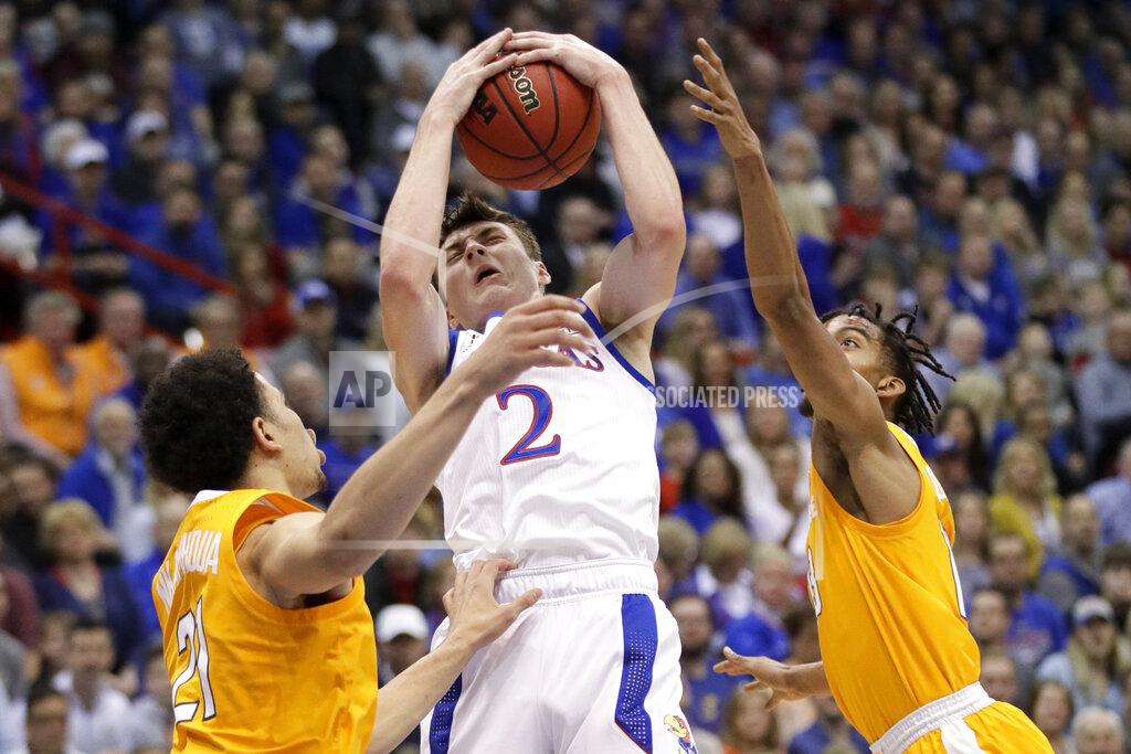 Orlin Wagner Kansas guard Christian Braun, center, rebounds between Tennessee forward Olivier Nkamhoua, left, and guard Jalen Johnson, right, during the first half of an NCAA college basketball game in Lawrence, Kan., Saturday, Jan. 25, 2020. (AP Photo/Orlin Wagner)