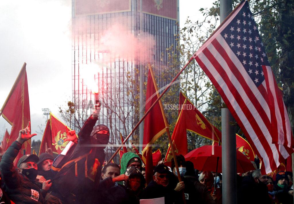 Risto Bozovic People shout slogans during a protest against the new government in Podgorica, Montenegro, Monday, Dec. 28, 2020. Several thousand people rallied Monday in Montenegro, accusing the new government of being pro-Serb because of its plans to amend a religious property law that is strongly opposed by the Serbian Orthodox Church. (AP Photo/Risto Bozovic)