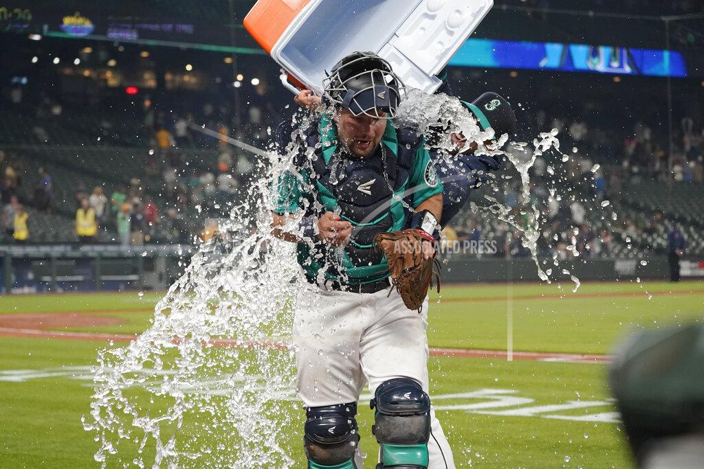 Ted S. Warren Seattle Mariners catcher Cal Raleigh has water and ice dumped onto him by teammate Tom Murphy as Raleigh takes part in an interview after the Mariners defeated the Oakland Athletics 4-3 in a baseball game Friday, July 23, 2021, in Seattle. (AP Photo/Ted S. Warren)