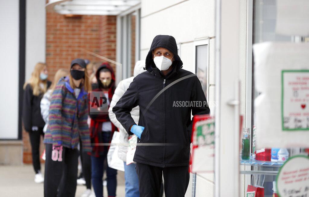 Brian Hill A line of socially distanced shoppers wait to get into Bath & Body Works during Black Friday outdoor shopping at Deer Park Town Center Friday, Nov. 27, 2020, in Deer Park, Ill. (Brian Hill/Daily Herald via AP)