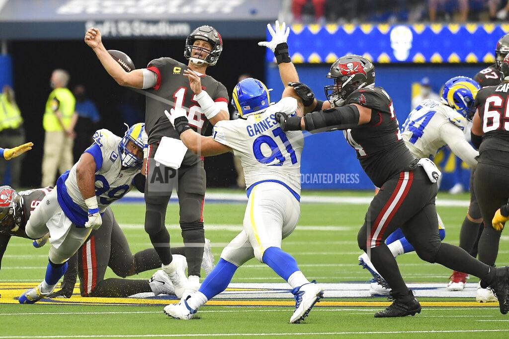 Kevork Djansezian CORRECTS TO DEFENSIVE END AARON DONALD, FRONT LEFT, NOT TIGHT END TYLER HIGBEE (89) - Tampa Bay Buccaneers quarterback Tom Brady (12) loses the ball as he throws under pressure from Los Angeles Rams defensive end Aaron Donald, front left, during the first half of an NFL football game Sunday, Sept. 26, 2021, in Inglewood, Calif. Tampa Bay recovered the ball on the play. (AP Photo/Kevork Djansezian)