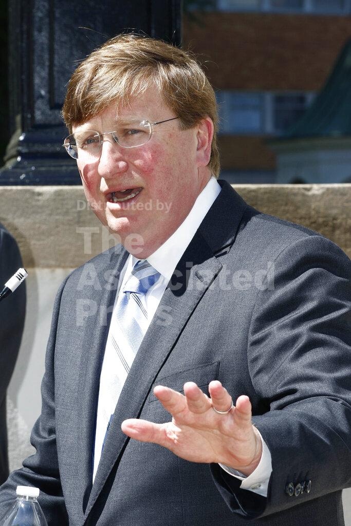 Gov. Tate Reeves speaks to reporters clarifying his earlier issued executive order regarding COVID-19 issues, during a news conference outside the Governor's Mansion, Thursday, March 26, 2020 in Jackson, Miss. (AP Photo/Rogelio V. Solis)