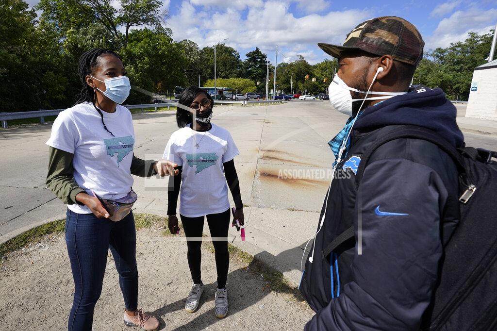 Paul Sancya Wendy Caldwell-Liddell, from left, who helped start Mobilize Detroit, and Paris Powell talk with a voter in Detroit, Friday, Sept. 18, 2020. Both President Donald Trump and Democratic presidential nominee Joe Biden are battling for support among Black voters across Michigan, and Biden's running mate, Sen. Kamala Harris, will be in the state on Tuesday, Sept. 22. (AP Photo/Paul Sancya)