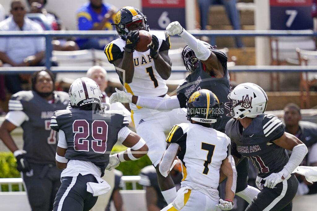 Rogelio V. Solis Arkansas-Pine Bluff wide receiver Harry Ballard III (1) catches a pass while surrounded by Alabama A&M defenders during the first half of the Southwestern Athletic Conference NCAA college football game, Saturday, May 1, 2021, in Jackson, Miss. (AP Photo/Rogelio V. Solis)