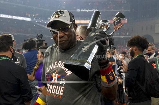 Houston Astros manager Dusty Baker Jr. holds the trophy after their win against the Boston Red Sox in Game 6 of baseball's American League Championship Series Friday, Oct. 22, 2021, in Houston. The Astros won 5-0, to win the ALCS series in game six. (AP Photo/Tony Gutierrez)