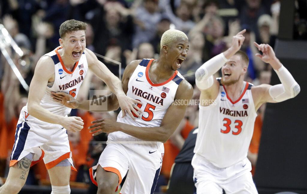 Michael Conroy FILE - In this March 30, 2019, file photo, Virginia's Mamadi Diakite, center, reacts with teammates Kyle Guy and Jack Salt (33) after hitting a shot against Purdue to send the game into overtime in a regional final of the NCAA college basketball tournament in Louisville, Ky. (AP Photo/Michael Conroy, File)