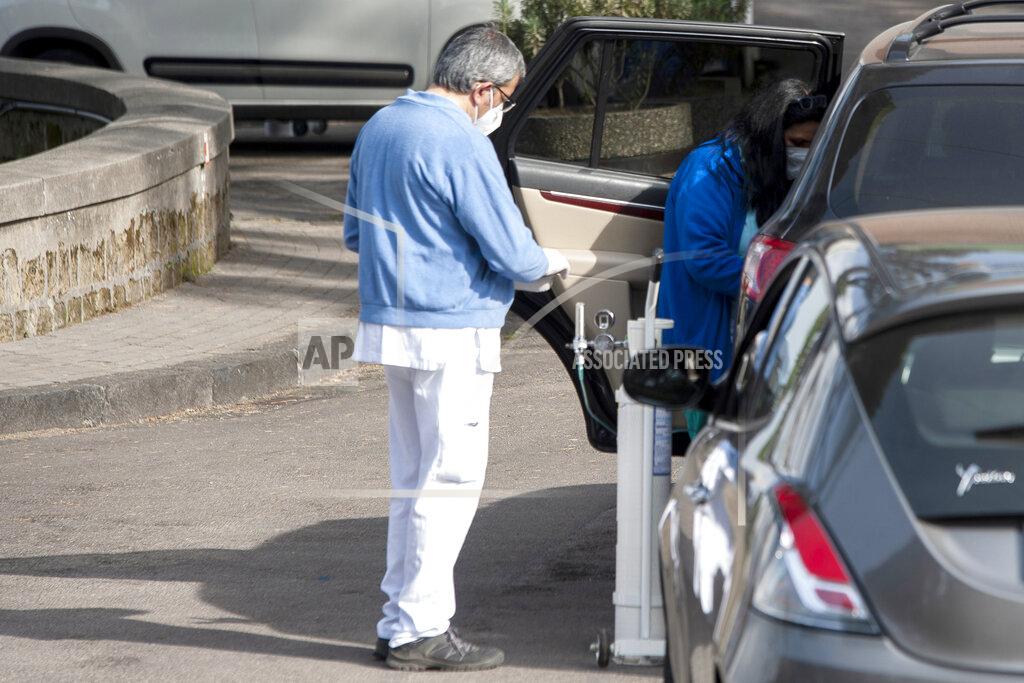 Valeria Ferraro FILE - In this Saturday, Nov. 14, 2020 file photo, hospital personnel with an oxygen tank check a passenger in a car waiting in line at the Cotugno hospital in Naples, southern Italy, Saturday, Nov. 14, 2020. The coronavirus pandemic has heightened the urgency of the plight of those seeking medical care in public hospitals in Italy’s economically underdeveloped south. (Valeria Ferraro/LaPresse via AP)