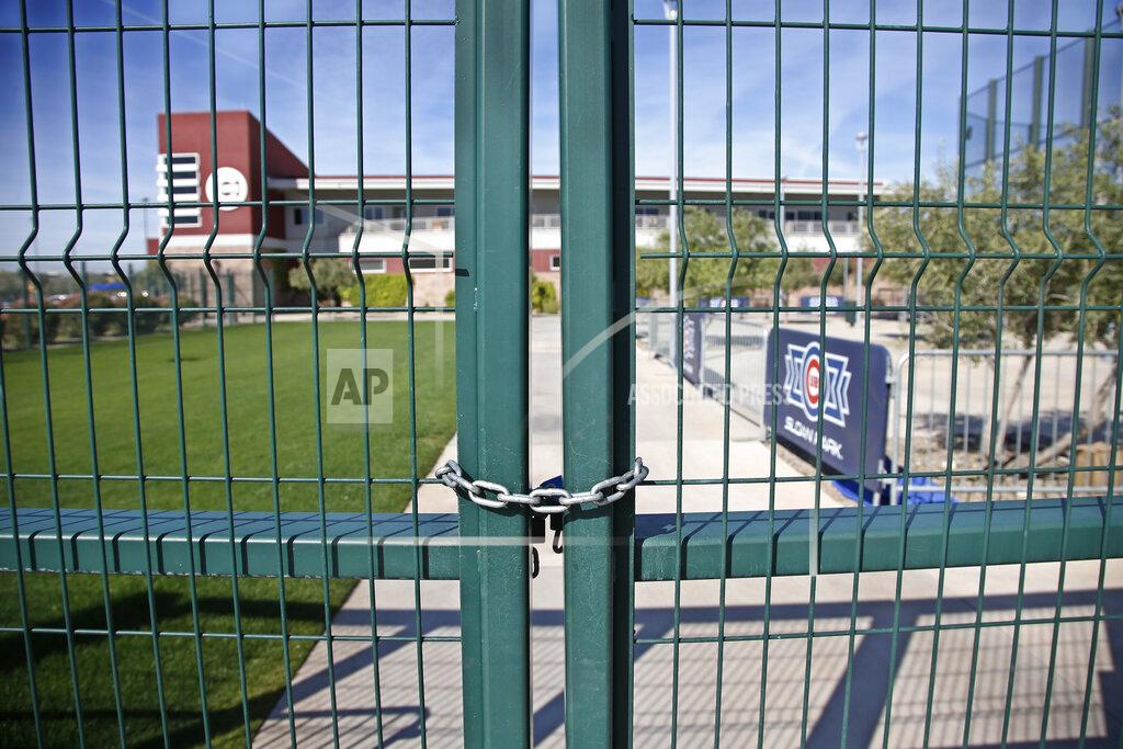 Sue Ogrocki FILE - A gate at the Chicago Cubs practice facility at Sloan Park in Mesa, Ariz., is closed and locked due to the coronavirus, in this Monday, March 16, 2020, file photo. Big league managers say that Major League Baseball has instructed them to prepare for spring training to start on time in mid-February despite uncertainty around the coronavirus. Tampa Bay Rays manager Kevin Cash said Wednesday, Dec. 16, 2020, that officials from the commissioner's office had a meeting with managers Tuesday an expressed optimism about opening spring camps as scheduled. (AP Photo/Sue Ogrocki, File)