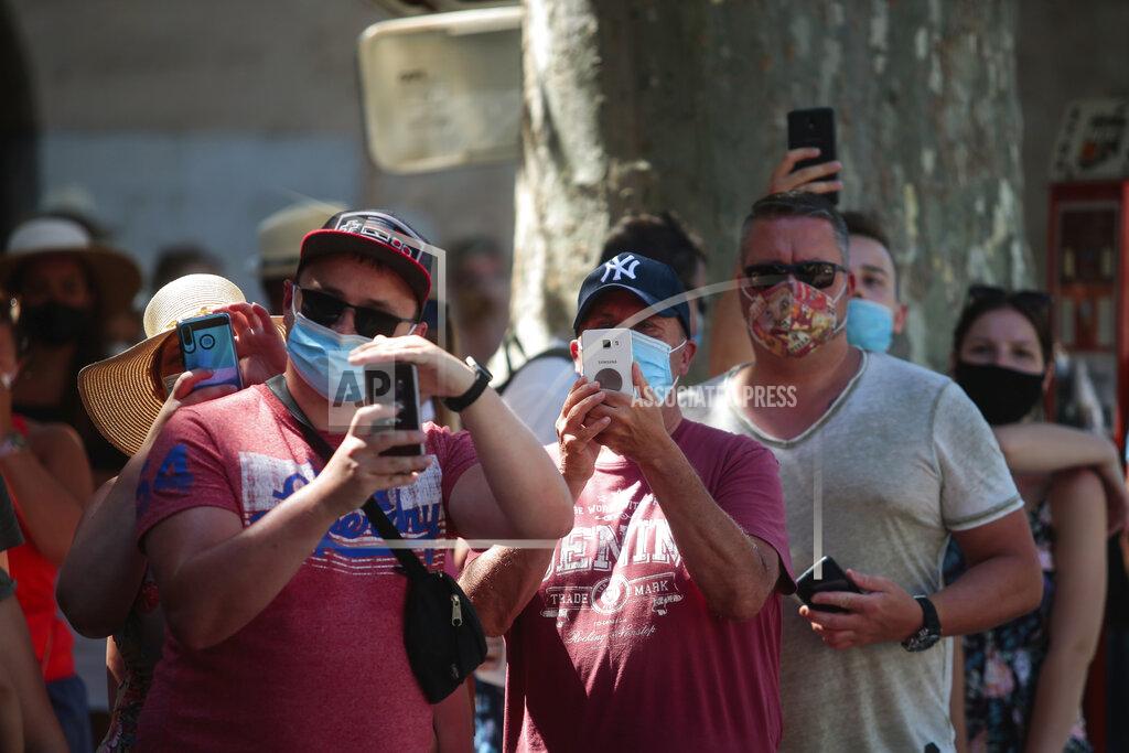 Joan Mateu FILE - In this Monday, July 27, 2020 file photo, tourists take photos in the town of Soller in the Balearic Island of Mallorca, Spain. Faced with a possible flood of visitors from Germany later this month, authorities in Spain’s Balearic Islands are warning hotel owners that tourists must adhere to coronavirus restrictions the same way residents do. The archipelago in the Mediterranean Sea is strengthening measures to combat the virus before the Easter period. But the restrictions haven’t stopped eager German tourists who have rushed to book flights and accommodation this week following their government’s removal of the islands from a list of high-risk contagion zones. (AP Photo/Joan Mateu, FIle)
