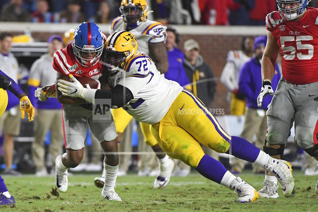 Thomas Graning FILE - LSU nose tackle Tyler Shelvin (72) tackles Mississippi wide receiver Elijah Moore (8) during the second half of an NCAA college football game in Oxford, Miss., Saturday, Nov. 16, 2019. LSU coach Ed Orgeron says defensive lineman Neil Farrell has rejoined the team after initially opting out more than a month ago. Orgeron says he's also hearing “rumblings” that defensive lineman Tyler Shelvin could opt back. (AP Photo/Thomas Graning, File)