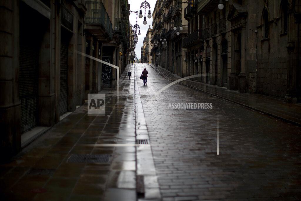 Emilio Morenatti A man walks along an empty street in downtown Barcelona, Spain, Monday, April 20, 2020 as the lockdown to combat the spread of coronavirus continues. (AP Photo/Emilio Morenatti)