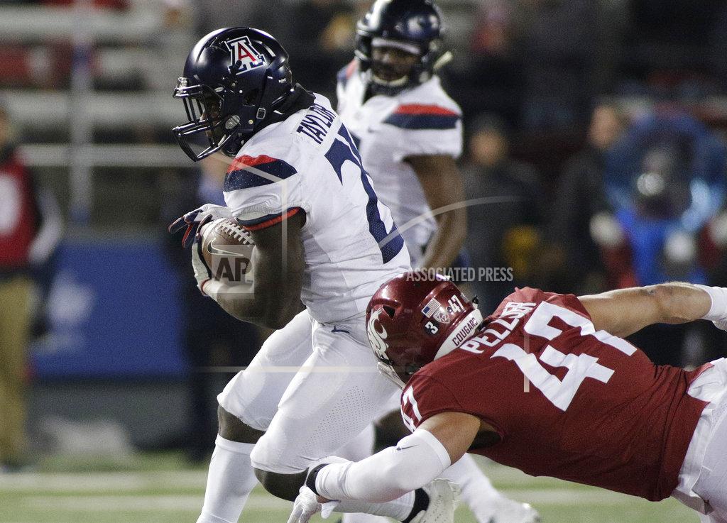 Young Kwak Arizona running back J.J. Taylor, left, runs with the ball while under pressure from Washington State linebacker Peyton Pelluer (47) during the second half of an NCAA college football game in Pullman, Wash., Saturday, Nov. 17, 2018. Washington State won 69-28. (AP Photo/Young Kwak)