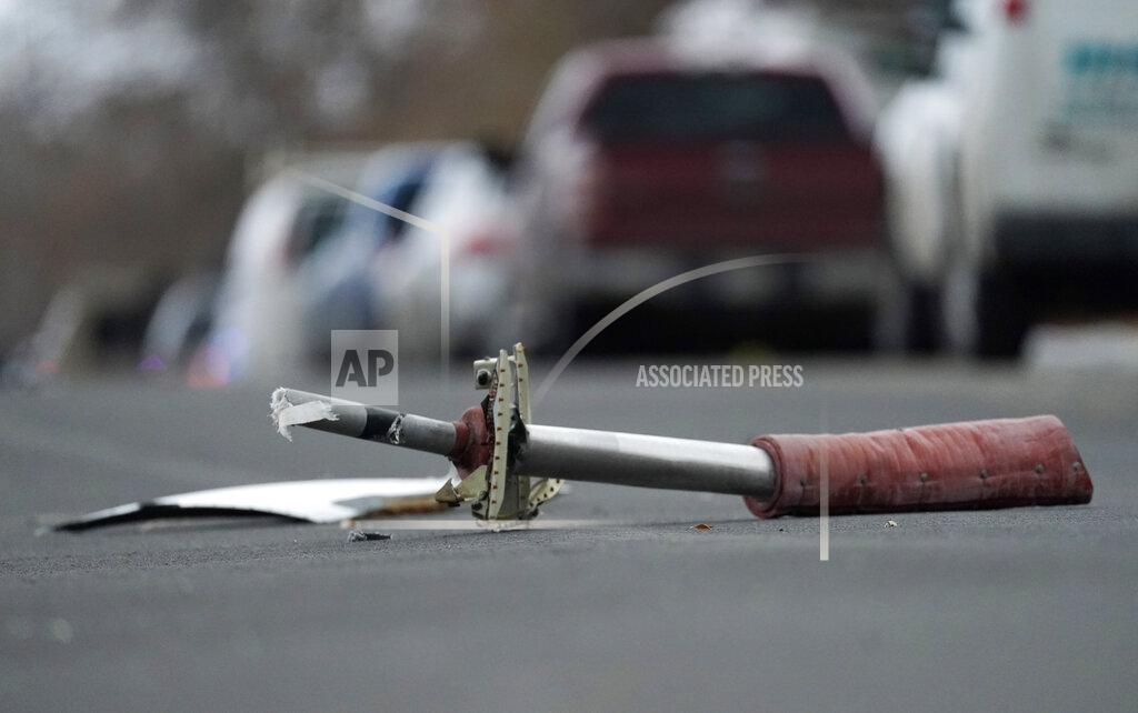 David Zalubowski A part from a United Airlines jetliner sits in the middle of Elmwood Street in the street near a home peppered by parts from a plane as it was making an emergency landing at nearby Denver International Airport Saturday, Feb. 20, 2021. (AP Photo/David Zalubowski)