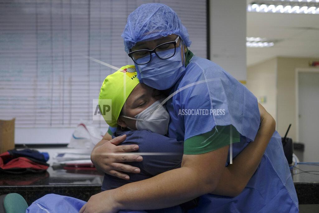 Matias Delacroix Health workers of the COVID-19 area embrace at the end of their shift at the Ana Francisca Perez de Leon II public Hospital in Caracas, Venezuela, Tuesday, March 23, 2021. (AP Photo/Matias Delacroix)