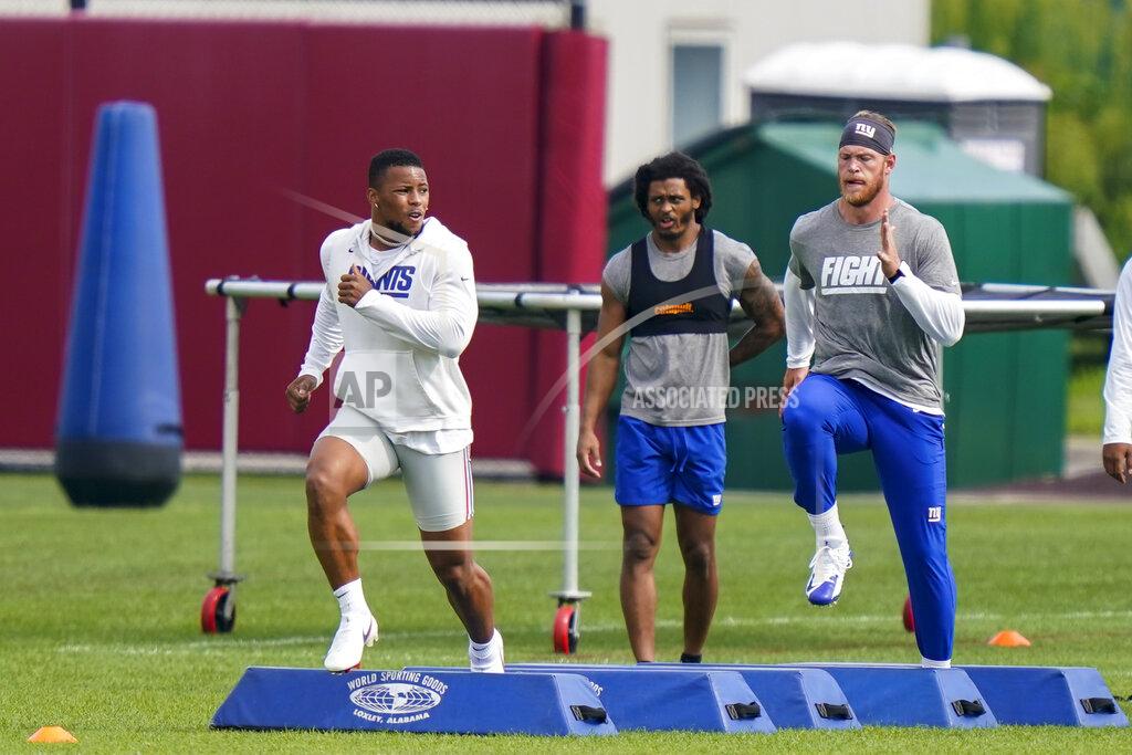 Corey Sipkin New York Giants running back Saquon Barkley, left, runs a drill at NFL football training camp, Wednesday, July 28, 2021, in East Rutherford, N.J. (AP Photo/Corey Sipkin)