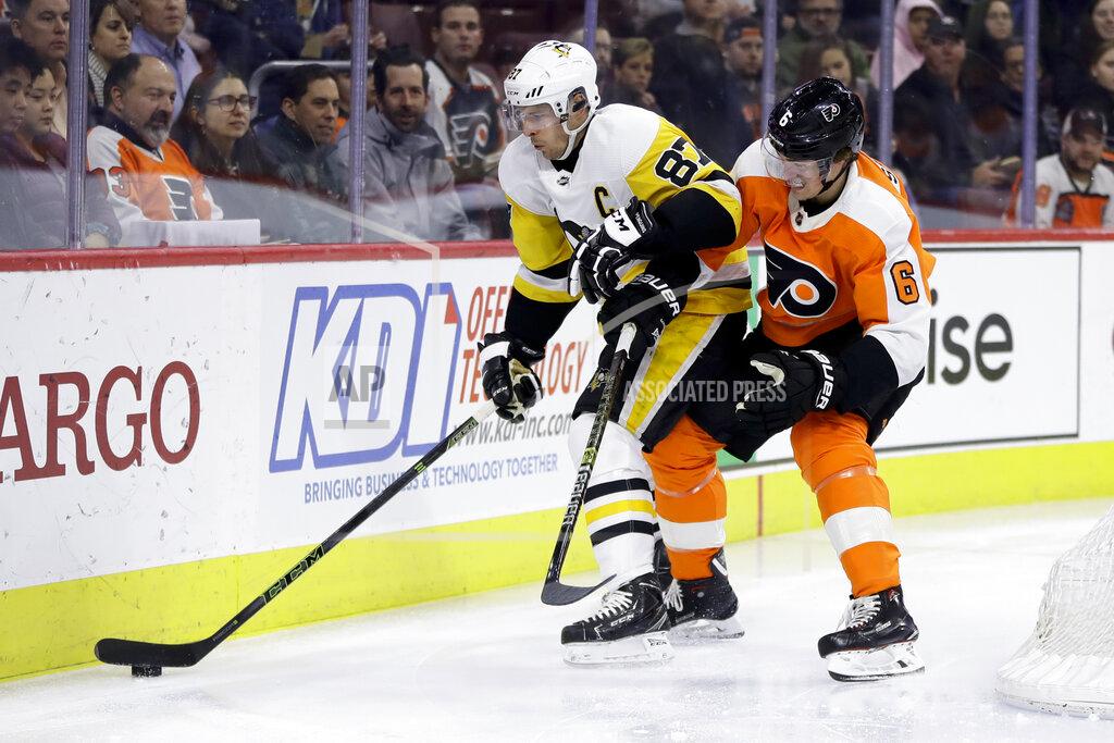 Pittsburgh Penguins' Sidney Crosby (87) and Philadelphia Flyers' Travis Sanheim (6) battle for the puck during the first period of an NHL hockey game, Monday, Feb. 11, 2019, in Philadelphia. (AP Photo/Matt Slocum)