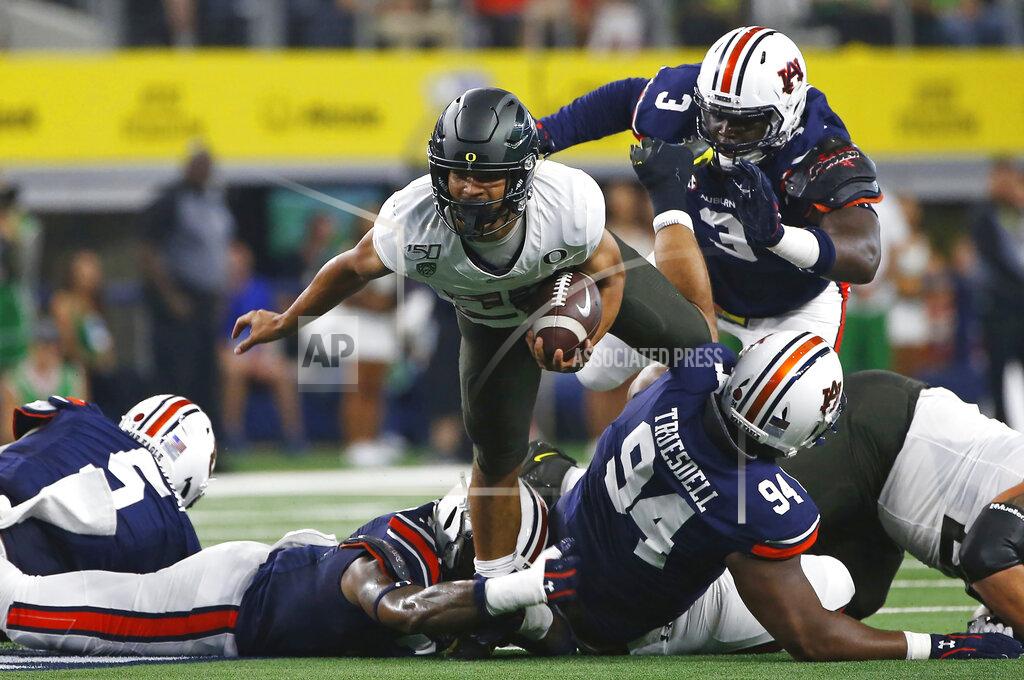 Ron Jenkins Oregon running back Travis Dye (26) runs for a short gain as Auburn defensive end Marlon Davidson (3) closes in during the first half of an NCAA college football game, Saturday, Aug. 31, 2019, in Arlington, Texas. (AP Photo/Ron Jenkins)
