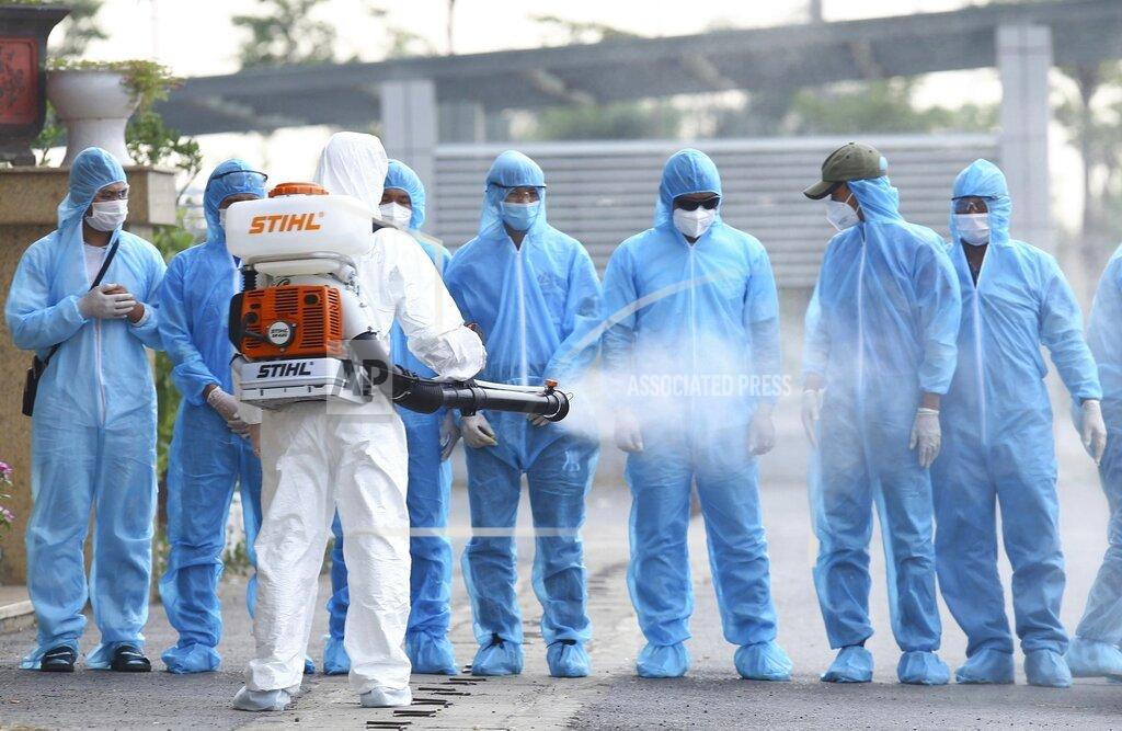 Bui Cuong Quyet A health worker disinfects arriving Vietnamese COVID-19 patients at the national hospital of tropical diseases in Hanoi, Vietnam on Wednesday, July 29, 2020. The 129 patients who were working in Equatorial Guinea were brought home in a repatriation flight for treatment of the coronavirus. (Bui Cuong Quyet/VNA via AP)