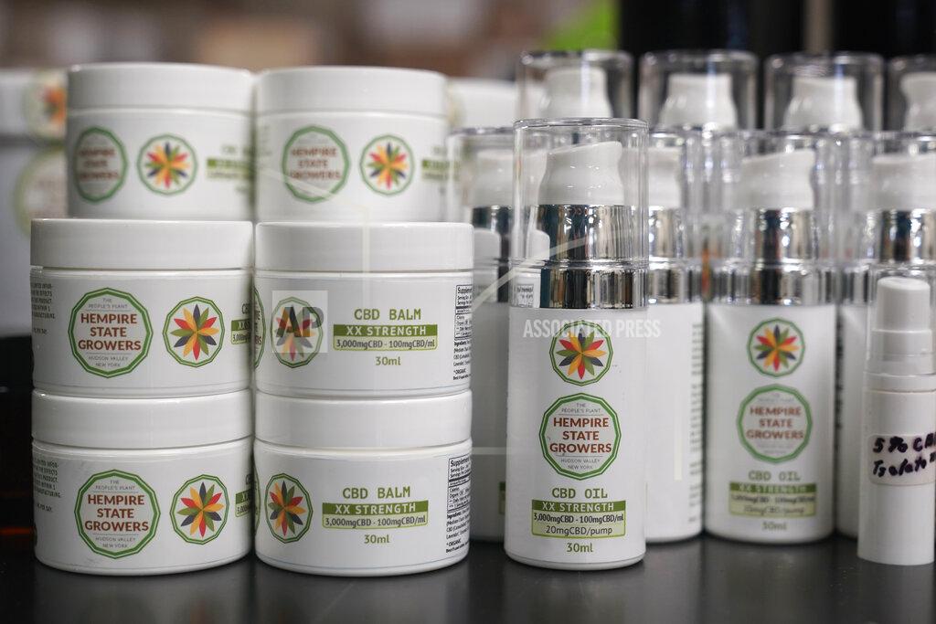 Seth Wenig Products made by Hempire State Growers are displayed in their offices at Hepworth Farms in Milton, N.Y., Monday, April 12, 2021. Farmers dealing with depressed prices for plants that produce CBD extract are eager to take part in a statewide marijuana market expected to generate billions of dollars a year once retail sales start. (AP Photo/Seth Wenig)