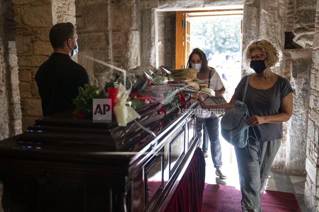 Petros Giannakouris Women pay their final respects to the late composer Mikis Theodorakis, in Athens, on Monday Sept. 6, 2021. Hundreds of people have gathered outside Athens Cathedral where Greek composer and politician Mikis Theodorakis is to lie in state in a chapel of the cathedral for three days ahead of his burial on the southern island of Crete. (AP Photo/Petros Giannakouris)