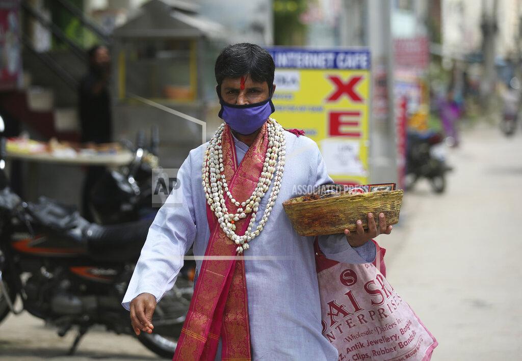Mahesh Kumar A A Hindu religious man wearing a face mask as a precaution against the coronavirus walks on a street in Hyderabad, India, Thursday, Oct. 15, 2020. (AP Photo/Mahesh Kumar A.)