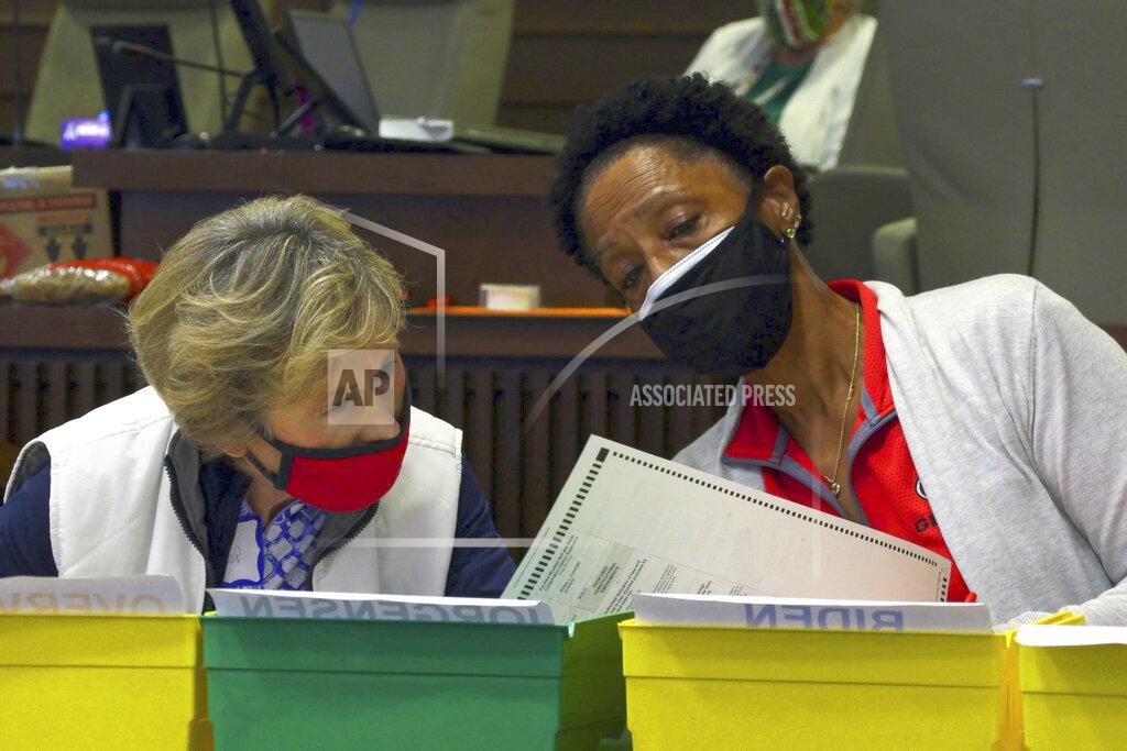 Uncredited Bipartisan teams of Democrats and Republicans work on an audit of Friday, Nov. 13, 2020, in Council Chambers at the City Services Center, in Columbus, Ga. Election officials in Georgia's 159 counties started counting ballots Friday morning for a hand tally of the presidential race that stems from an audit required by state law. (Mike Haskey/Ledger-Enquirer via AP)