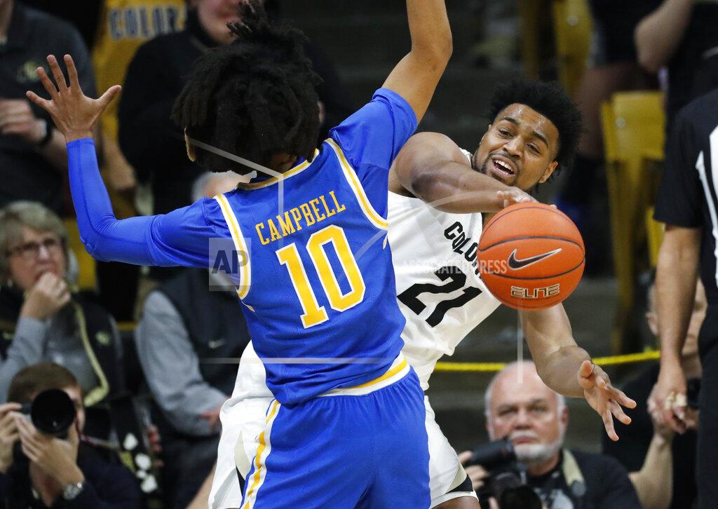 David Zalubowski Colorado forward Evan Battey, back, passes the ball as UCLA guard Tyger Campbell defends in the first half of an NCAA college basketball game Saturday, Feb. 22, 2020, in Boulder, Colo. (AP Photo/David Zalubowski)