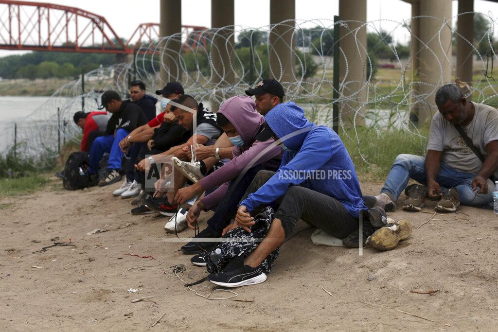 Dario Lopez-Mills Migrants who had crossed the Rio Grande river into the U.S., remove their shoelaces and others personal items while under custody of National Guard members as they await the arrival of U.S. Border Patrol agents in Eagle Pass, Texas, Friday, May 20, 2022. As U.S. officials anxiously waited, many of the migrants crossing the border from Mexico on Friday were oblivious to a pending momentous court ruling on whether to maintain pandemic-related powers that deny a chance to seek asylum on grounds of preventing the spread of COVID-19. (AP Photo/Dario Lopez-Mills)