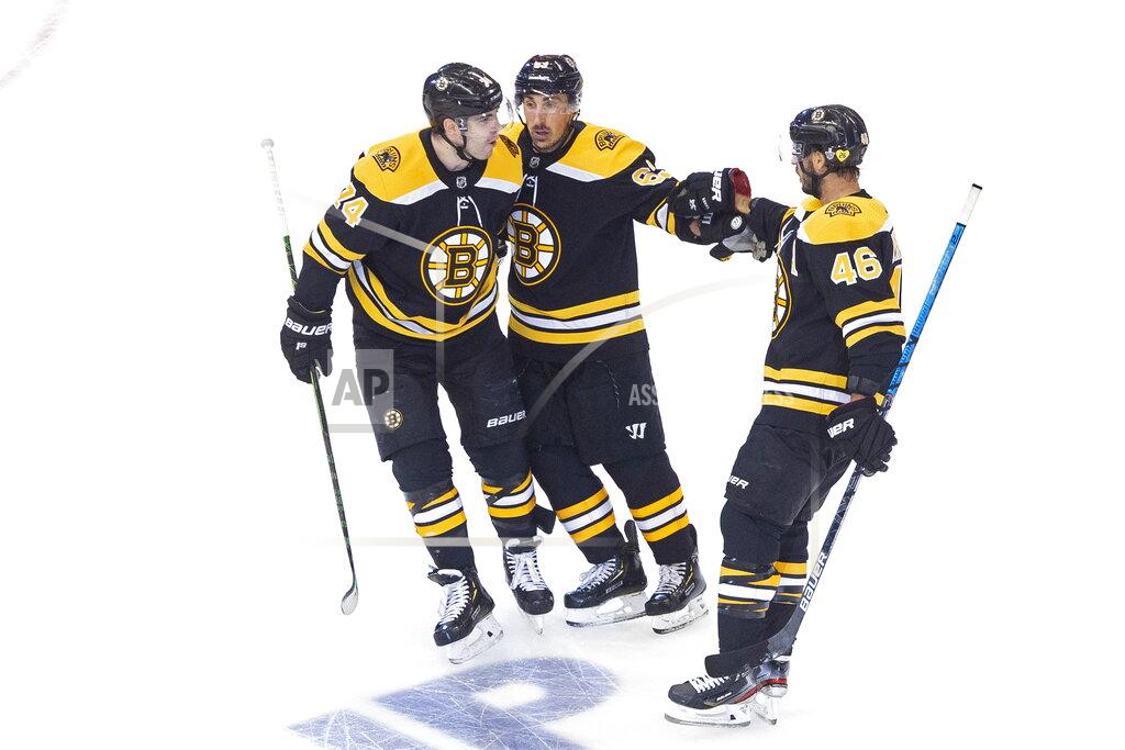 Chris Young Boston Bruins' David Krejci (46) celebrates his goal against the Carolina Hurricanes with teammates Jake DeBrusk (74) and Brad Marchand (63) during the first period of an NHL Eastern Conference Stanley Cup hockey playoff game in Toronto, Thursday, Aug. 13, 2020. (Chris Young/The Canadian Press via AP)