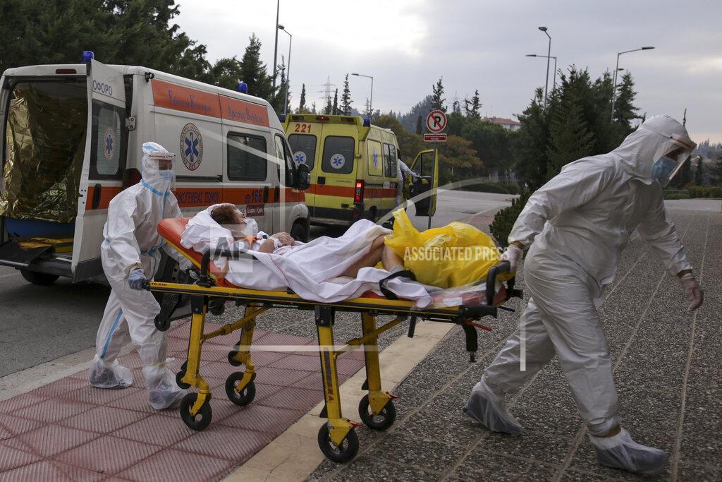 Achilleas Chiras Medical personnel transfer a COVID-19 patient from a state to a private clinic which has been appropriated, in the northern city of Thessaloniki, Greece, Sunday, Nov. 29, 2020. Greece's Health ministry has forcibly appropriated two clinics and their staff in the country's second populated city, where the outbreak is the most severe. (AP Photo/Achilleas Chiras)