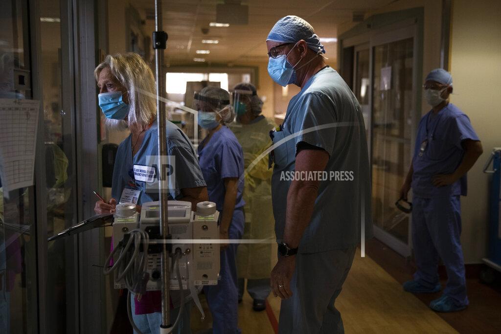 Jae C. Hong FILE - In this July 7, 2020, file photo, Nurse Cindy Kelbert, left, checks on a critically ill COVID-19 patient through a glass door as she is surrounded by other nurses at St. Jude Medical Center in Fullerton, Calif. The U.S. death toll from COVID-19 has almost topped 500,000 — a number so staggering that a top health researchers says it is hard to imagine an American who hasn't lost a relative or doesn't know someone who died. (AP Photo/Jae C. Hong)