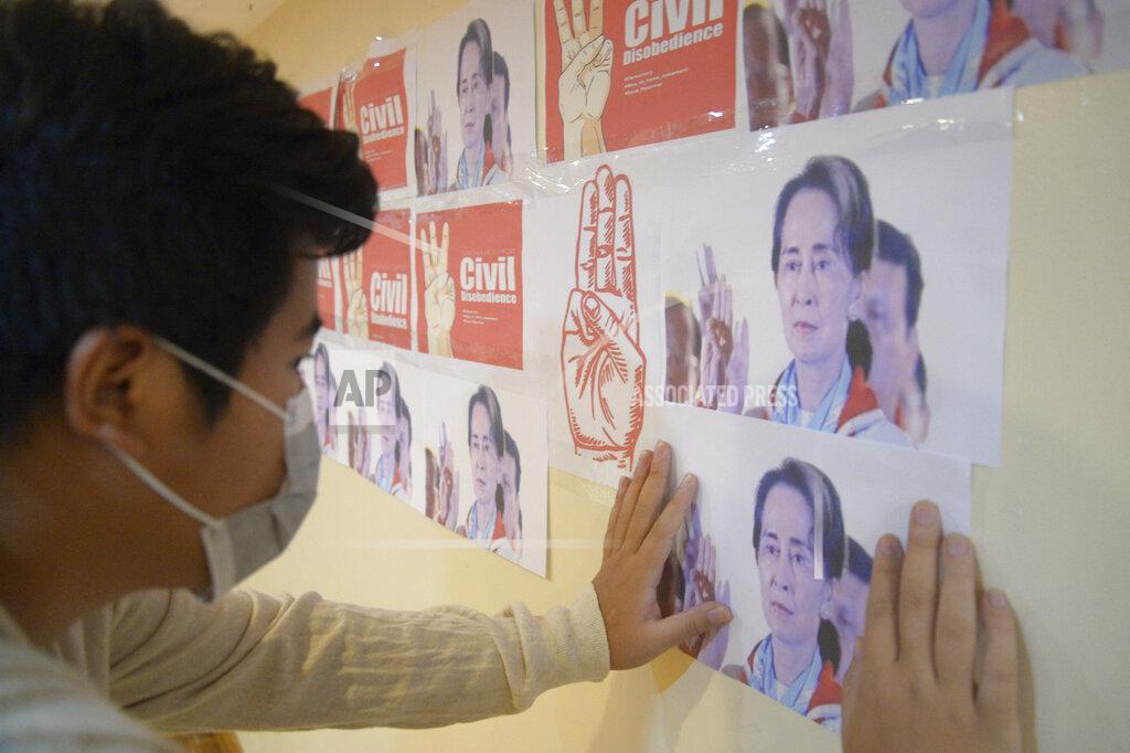 Uncredited An anti-coup protester looks at the images of ousted Myanmar leader Aung San Suu Kyi during a protest against the military coup in Yangon, Myanmar, on Monday, April 26, 2021. Southeast Asian leaders have demanded an immediate end to killings and the release of political detainees in Myanmar during an emergency summit in Jakarta with its top general and coup leader. (AP Photo)