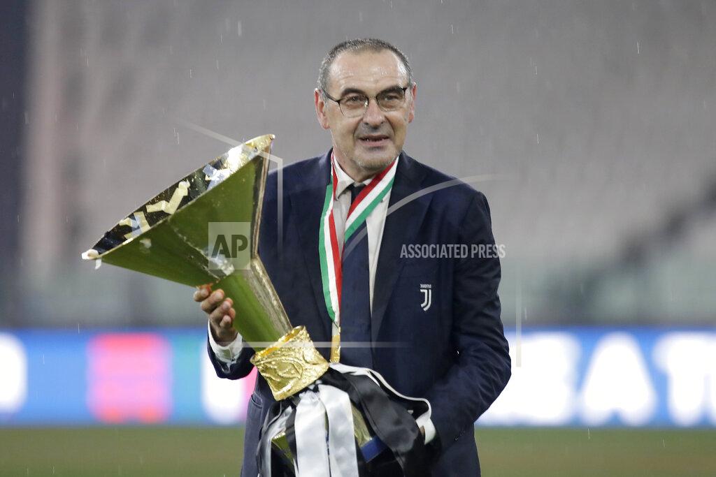 Luca Bruno Juventus' head coach Maurizio Sarri poses for photograph as holds the trophy while Juventus players celebrate winning an unprecedented ninth consecutive Italian Serie A soccer title, at the end of the a Serie A soccer match between Juventus and Roma, at the Allianz stadium in Turin, Italy, Saturday, Aug.1, 2020. (AP Photo/Luca Bruno)