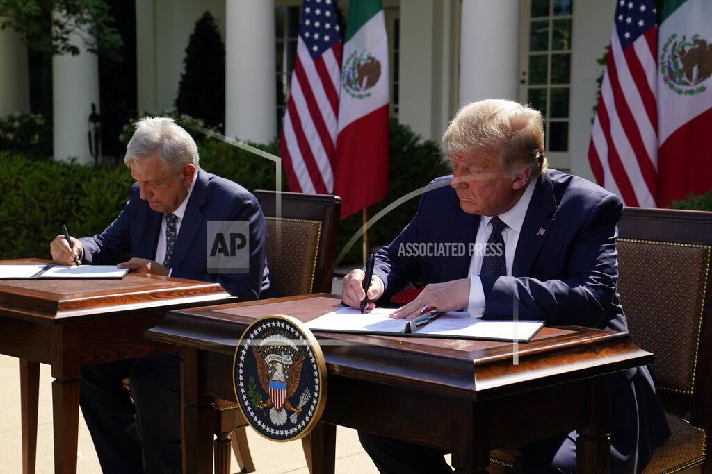 Evan Vucci President Donald Trump and Mexican President Andres Manuel Lopez Obrador sign a joint declaration at the White House, Wednesday, July 8, 2020, in Washington. (AP Photo/Evan Vucci)