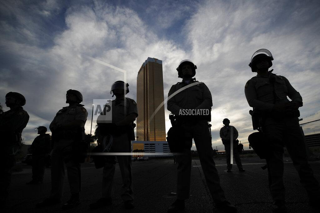 Police stand guard as protesters rally at the Trump Tower, Monday, June 1, 2020, in Las Vegas, over the death of George Floyd. Floyd, a black man, died after being restrained by Minneapolis police officers on Memorial Day. (AP Photo/John Locher)