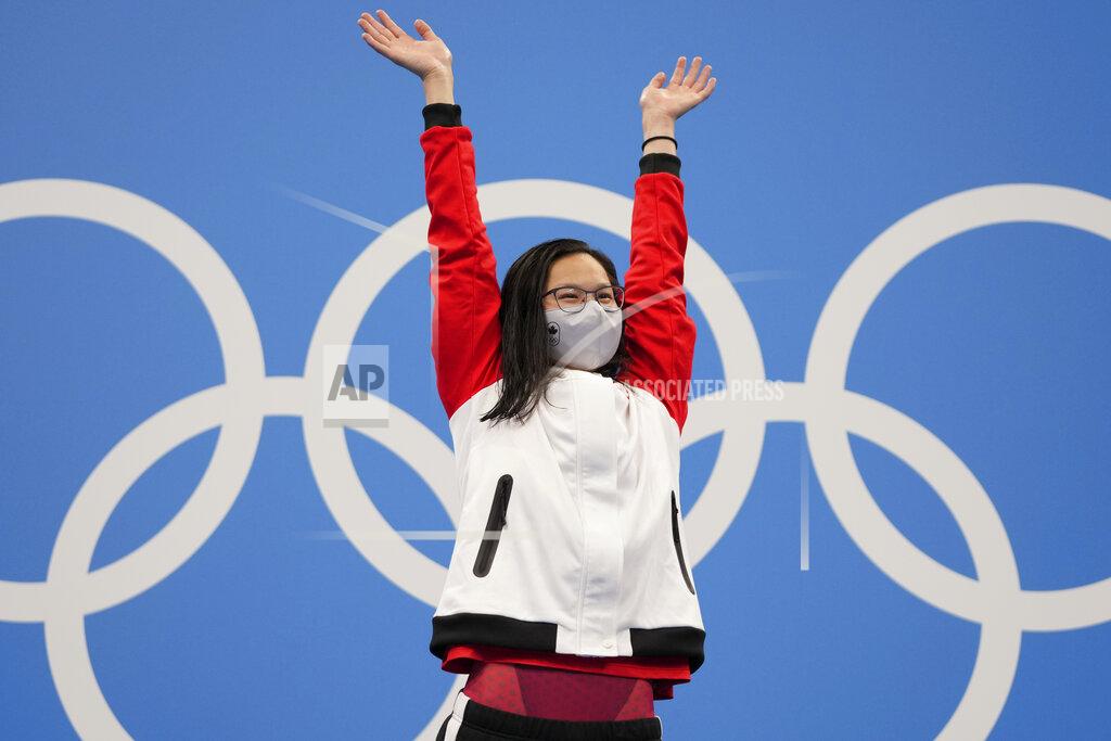 Matthias Schrader Margaret MacNeil of Canada celebrates on the podium after winning the women's 100-meter butterfly final at the 2020 Summer Olympics, Monday, July 26, 2021, in Tokyo, Japan. (AP Photo/Matthias Schrader)
