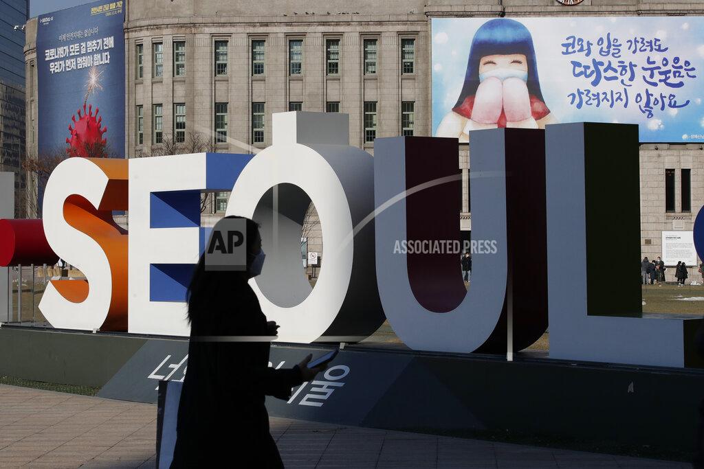 Lee Jin-Man A woman wearing a face mask as a precaution against the coronavirus walks near the display of South Korea's capital Seoul logo in Seoul, South Korea, Monday, Dec. 21, 2020. (AP Photo/Lee Jin-man)