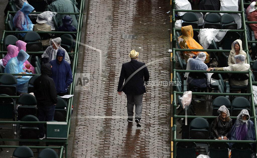 Charlie Riedel Fans wait in the rain before the 145th running of the Kentucky Derby horse race at Churchill Downs Saturday, May 4, 2019, in Louisville, Ky. (AP Photo/Charlie Riedel)