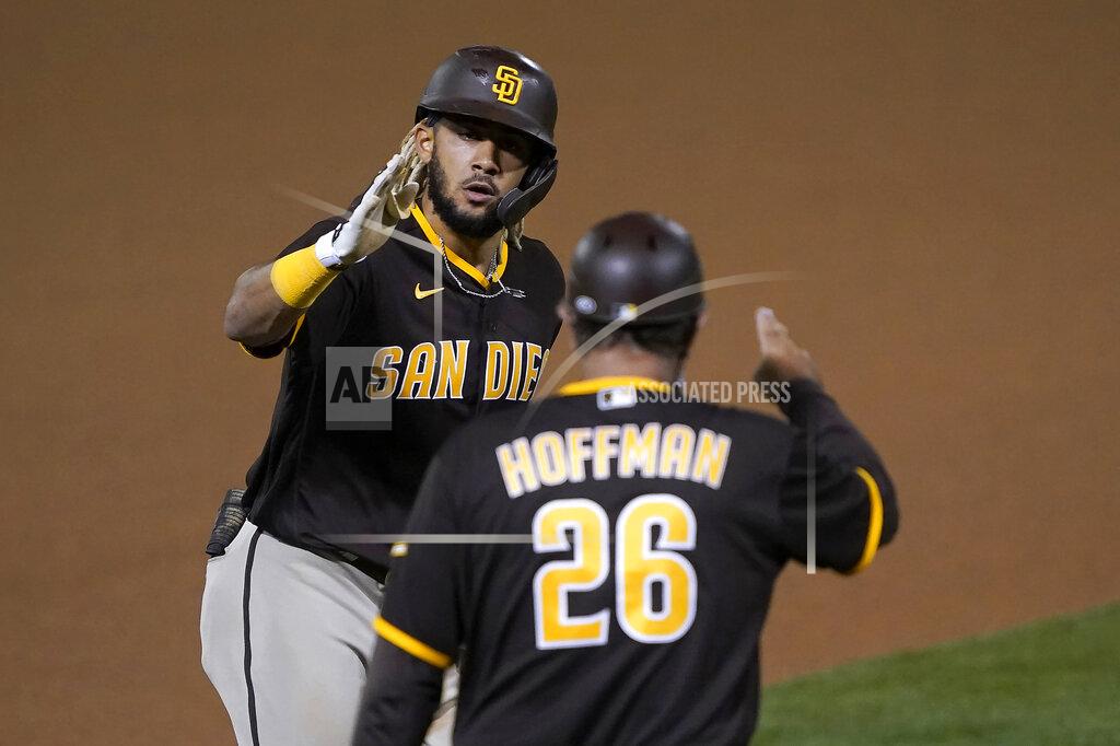 Tony Avelar San Diego Padres' Fernando Tatis Jr. (23) is congratulated by third base coach Glenn Hoffman after hitting a solo home run against the Oakland Athletics during the seventh inning of a baseball game in Oakland, Calif., Friday, Sept. 4, 2020. (AP Photo/Tony Avelar)