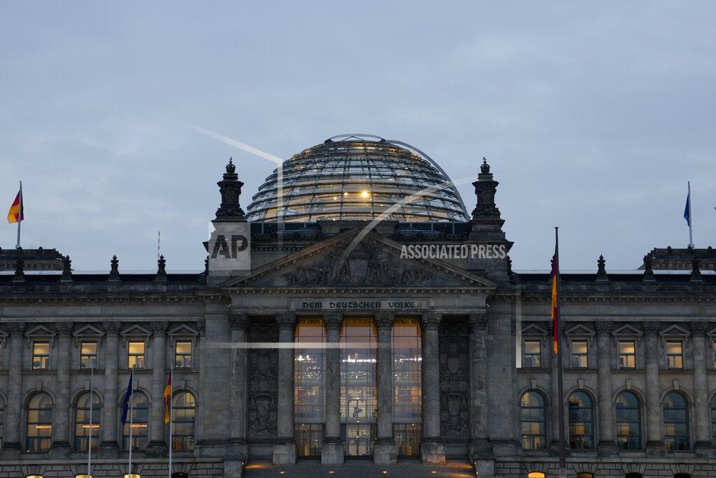 Markus Schreiber The building of German parliament, the Reichstag, is illuminated in Berlin, Tuesday, Oct. 26, 2021. Following the Sept. 26 national elections, the parliament Bundestag meet for a constituent parliamentary session. (AP Photo/Markus Schreiber)