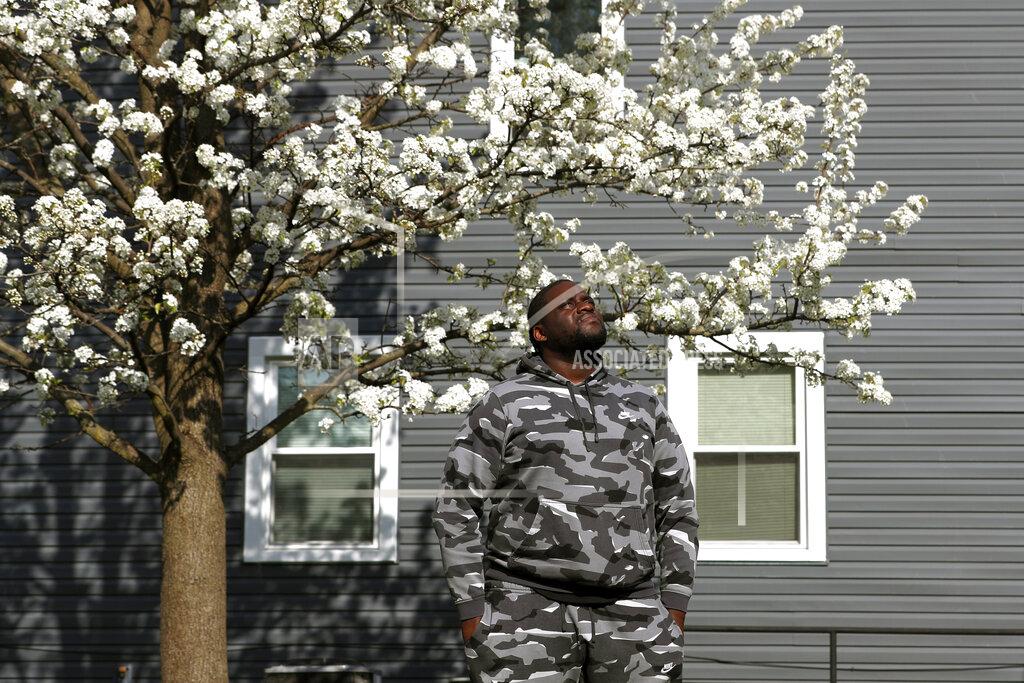 Shafkat Anowar Nikko Ross stands for a portrait at his home, Thursday, April 15, 2021, in Evanston, Ill. Acknowledging past racist policies, Evanston is giving eligible Black residents $25,000 housing grants for down payments, repairs or existing mortgages this year. He'll seek a grant, either for his down payment, or for his mother to repair her six-bedroom house. (AP Photo/Shafkat Anowar)