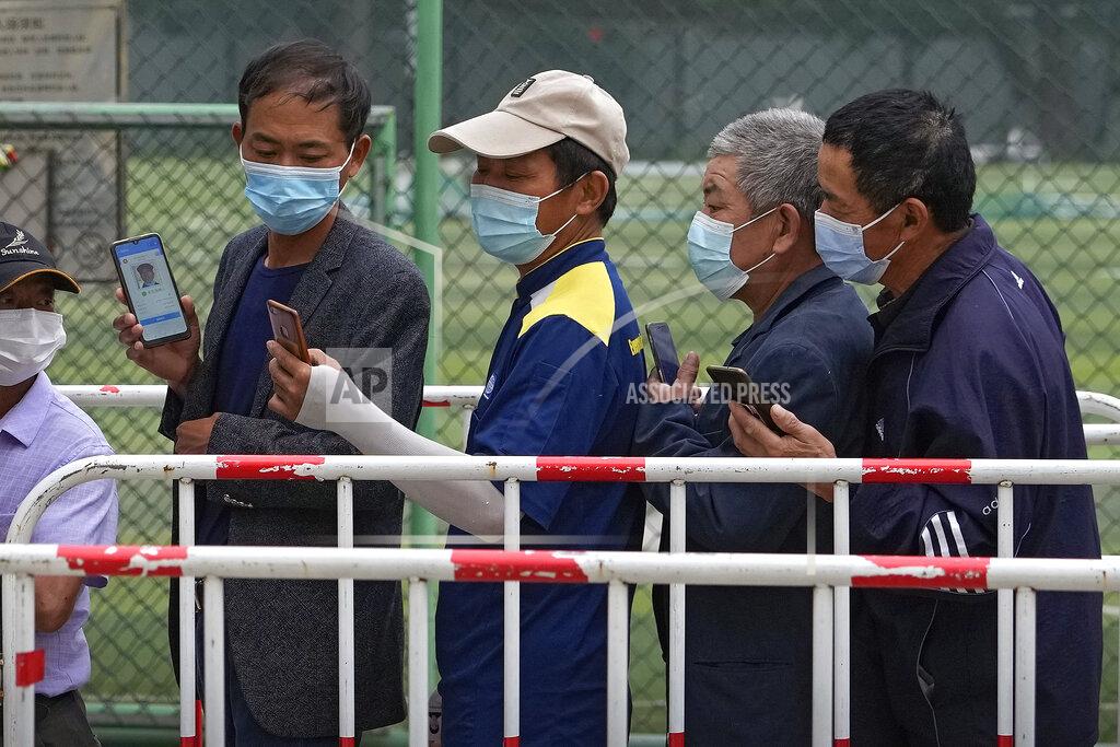 Andy Wong Residents wearing face masks to help curb the spread of the coronavirus look at their smartphones showing health code as they line up to receive the Sinopharm COVID-19 vaccine at a vaccination center in Central Business District in Beijing on Wednesday, June 2, 2021. After a slow start, China is now doing what virtually no other country in the world can: harnessing the power and all-encompassing reach of its one-party system and a maturing domestic vaccine industry to administer shots at a staggering pace. (AP Photo/Andy Wong)