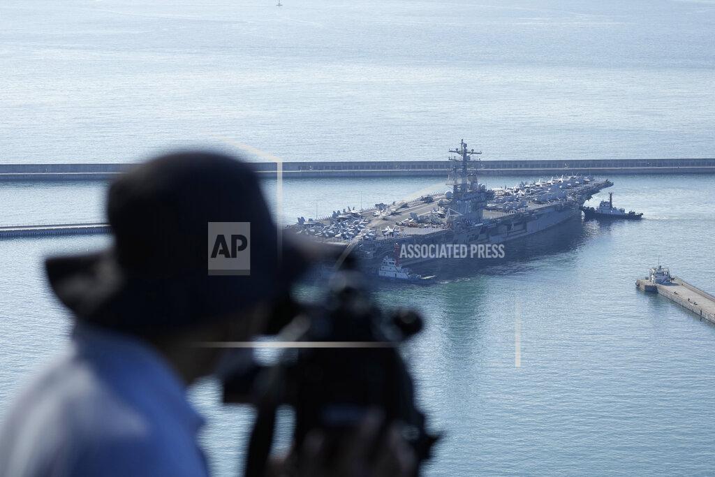Lee Jin-Man A TV cameraman films U.S. aircraft carrier USS Ronald Reagan entering port in Busan, South Korea, Friday, Sept. 23, 2022. The USS Ronald Reagan arrived to participate in upcoming joint military drills with South Korea in the East Sea – the first time since 2017. (AP Photo/Lee Jin-man)
