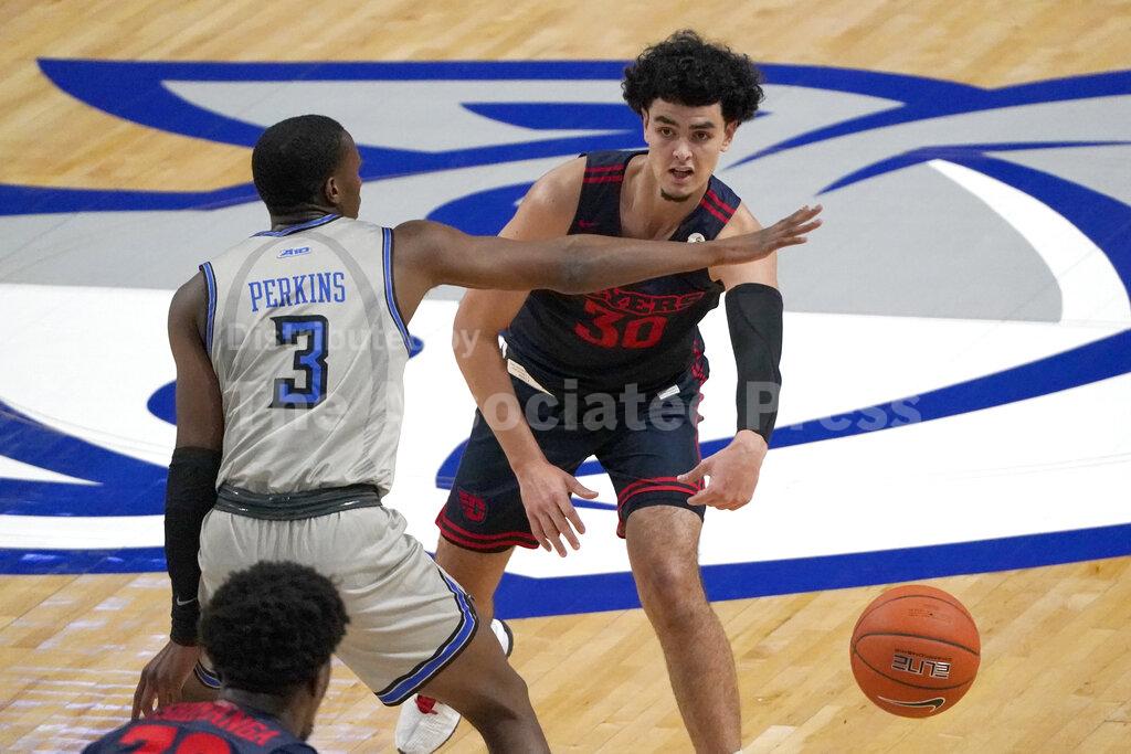 Dayton's Mustapha Amzil (30) passes around Saint Louis' Javonte Perkins (3) during the first half of an NCAA college basketball game Tuesday, Jan. 26, 2021, in St. Louis. (AP Photo/Jeff Roberson)