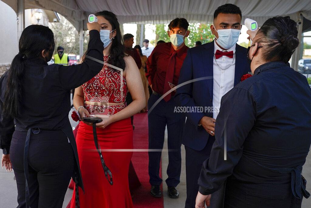 Paul Ratje Grace Gardens Event Center employees check temperatures of young people attending prom at the Grace Gardens Event Center in El Paso, Texas on Friday, May 7, 2021. Around 2,000 attended the outdoor event at the private venue after local school districts announced they would not host proms this year. Tickets cost $45. (AP Photo/Paul Ratje)